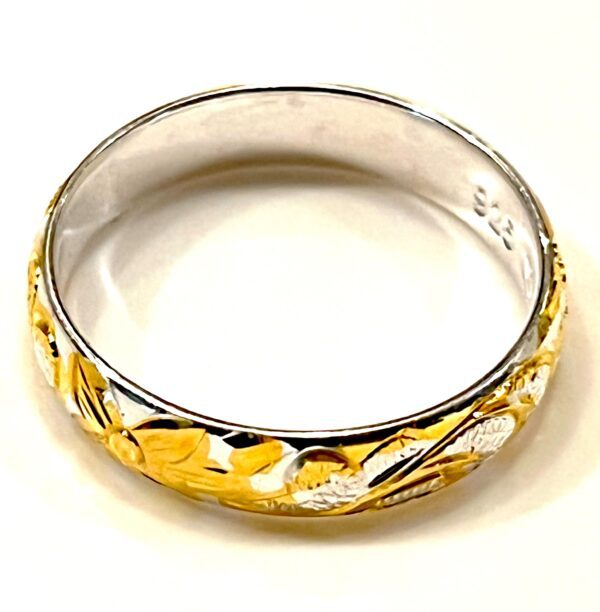 a silver and gold ring with a subtle design
